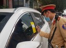 CSGT thực hiện việc dán thông báo xử phạt lên kính xe ô tô