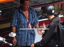 Phải cầm điện thoại để đưa tiền cho người bán nước dừa