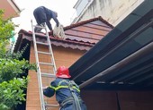 Cảnh sát bắc thang giải cứu người đàn ông rơi trúng mái nhà