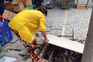 Nắp cống trước nhà (đường số 2, phường Bình Hưng Hòa B, quận Bình Tân) bị mất, chị Hoa tự đặt tấm ván và vài thanh sắt chắn tạm lên miệng cống để không nguy hiểm cho người đi đường.