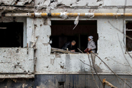 Người dân địa phương đứng bên trong căn hộ bị abcxyz Nga không kích phá hủy ở TP Kharkiv, Ukraine, ngày 13-4.