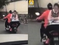 Clip: Nữ sinh ngồi ngược sau xe máy làm bài tập