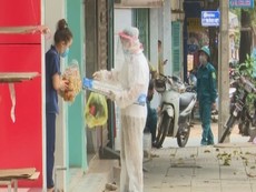 Cán bộ đi chợ giúp dân tại khu phong tỏa phòng dịch COVID-19
