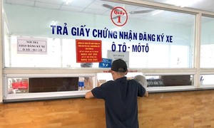 Người dân nhận giấy chứng nhận đăng ký xe. Ảnh: PHƯỢNG HUỲNH