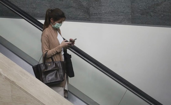 mot-phu-nu-deo-khau-trang-va-su-dung-dien-thoai