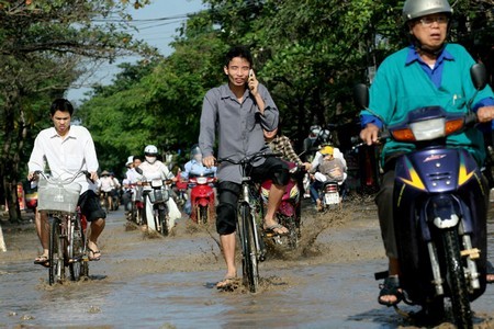 Mải mê nói chuyện điện thoại trong khi vượt đoạn đường ngập nước.