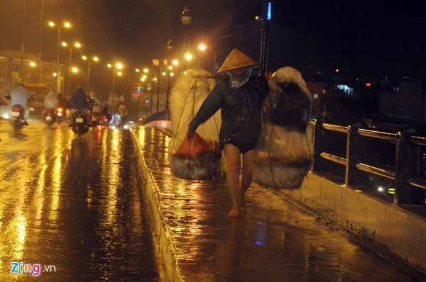 Sài Gòn bắt đầu vào mùa mưa, người phụ nữ buôn thúng bán ghánh đi như chạy dưới cơn mưa tầm tã.