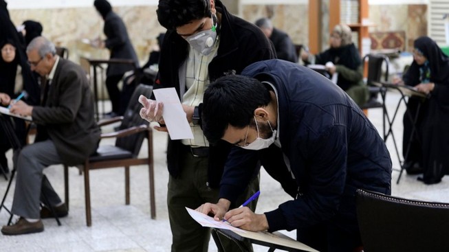 Cử tri ở Iran mang khẩu trang đi bỏ phiếu. Ảnh: AP