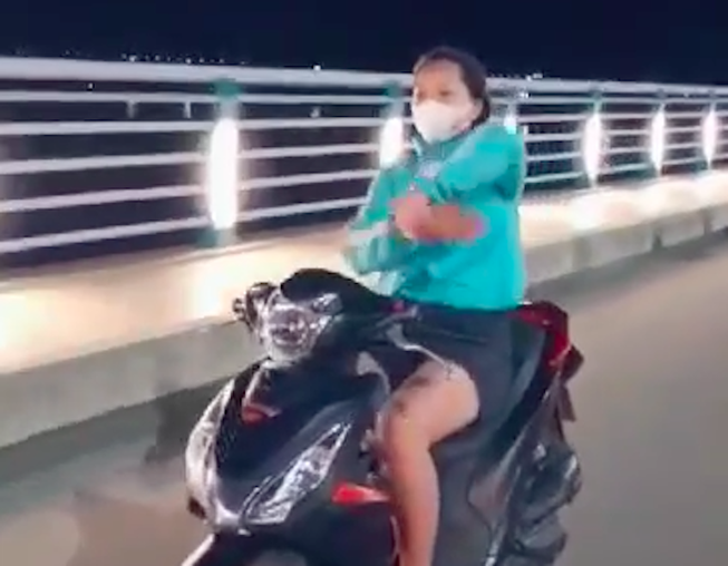 Cô gái buông tay lái xe máy, múa quạt giống Khá Bảnh