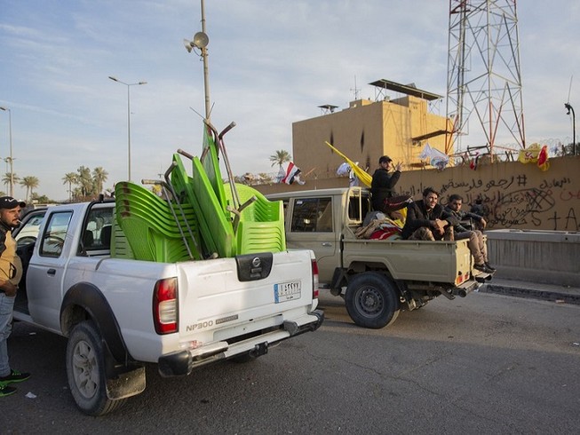 Người biểu tình thu dọn và rời khỏi Đại sứ quán Mỹ ở Baghdad. Ảnh: AP