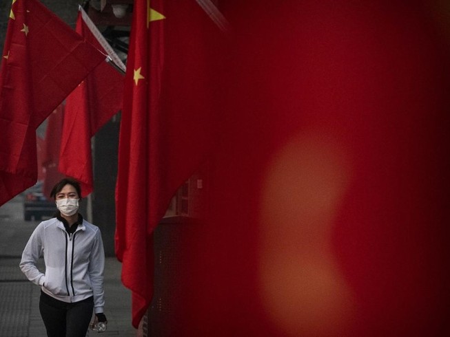 Một người phụ nữ đi bộ trên đường phố Vũ Hán (Ảnh chụp ngày 1-2). Ảnh: AFP