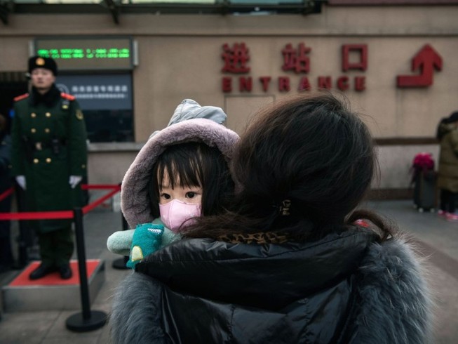 Một em bé cùng mẹ đứng đợi ở tàu ở ga Bắc Kinh ngày 1-2. Ảnh: GETTY IMAGES