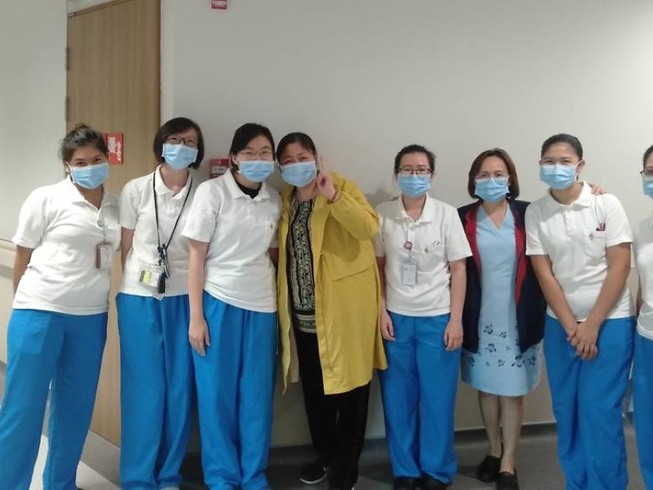 Bà Giang chụp ảnh cùng các y bác sĩ điều trị cho mình tại Trung tâm Phòng chống bệnh truyền nhiễm Singapore. Ảnh: CNA
