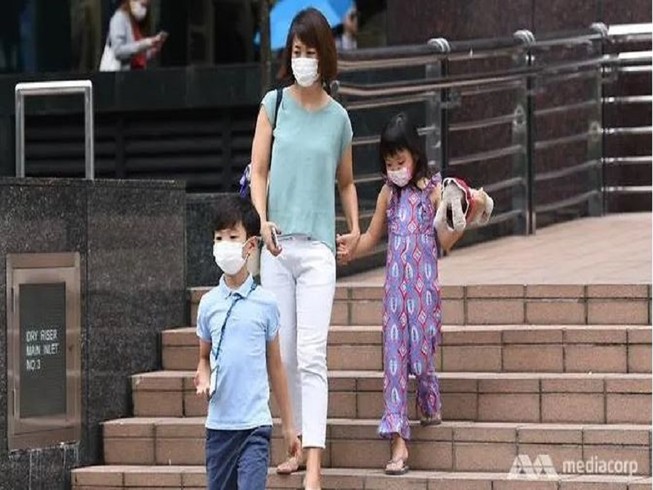 Người dân mang khẩu trang khi đi ra ngoài tại Singapore. Ảnh: CHANNEL NEWS ASIA