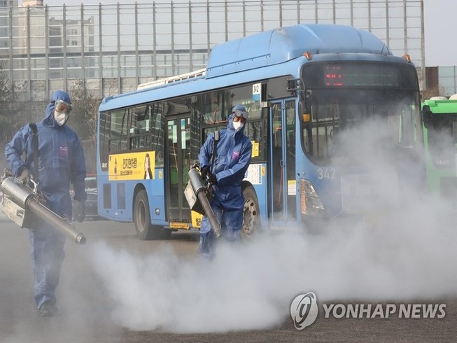 Các nhân viên y tế Hàn Quốc khử trùng tại một bến xe buýt ở thủ đô Seoul hôm 20-2. Ảnh: YONHAP