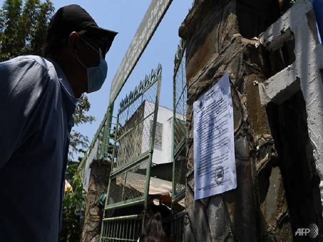 Người dân Campuchia đọc thông báo về đóng cửa trường học do đại dịch COVID-19. Ảnh: AFP