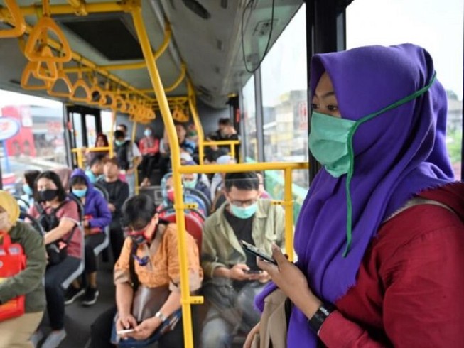 Người dân Indonesia đeo khẩu trang trên xe buýt như một biện pháp phòng dịch COVID-19. Ảnh: AFP