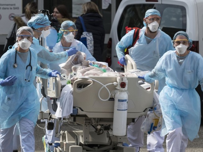 Nhân viên y tế di chuyển bệnh nhân nhiễm COVID-19 ở thủ đô Milan, Ý ngày 12-3. Ảnh: REUTERS