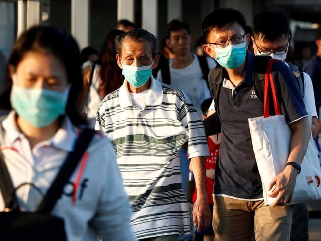 Người dân đeo khẩu trang ở Singapore, ngày 21-3. Ảnh: AFP