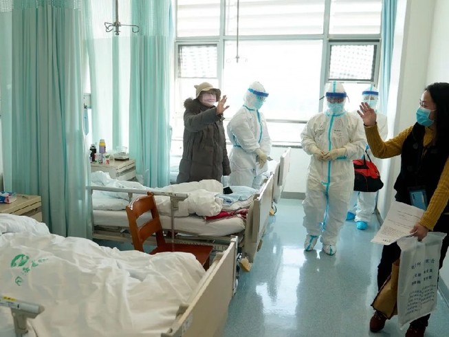 Một bệnh nhân được chữa khỏi COVID-19 ở Vũ Hán chào tạm biệt bác sĩ trước khi xuất viện. Ảnh: TÂN HOA XÃ