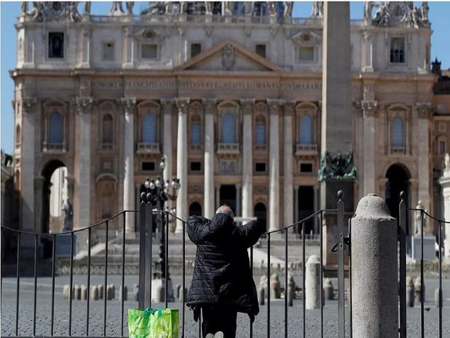 Một người đàn ông cầu nguyện trước Quảng trường Saint Peter ở TP Rome, Ý ngày 25-3. Ảnh: REUTERS