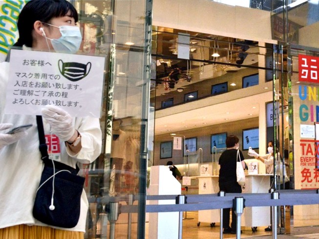 Khách hàng đeo khẩu trang mua sắm ở một cửa hàng Uniqlo ở thủ đô Tokyo, Nhật Bản hồi tháng 3-2020. Ảnh: REUTERS