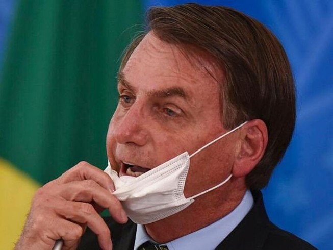 Tổng thống Brazil Jair Bolsonaro tháo khẩu trang tại một cuộc họp báo về COVID-19 vào tháng 3. Ảnh: Andre Borges/AP
