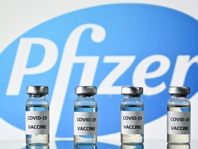 Những lọ vaccine ngừa COVID-19 đặc trước logo tập đoàn dược phẩm Pfizer.