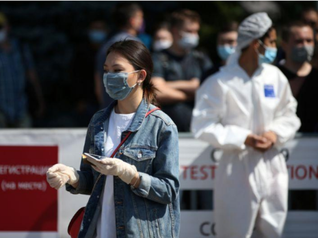 Người dân vẫn mang khẩu trang và găng tay trên đường phố TP Almaty (Kazakhstan) ngày 17-6. Ảnh: REUTERS
