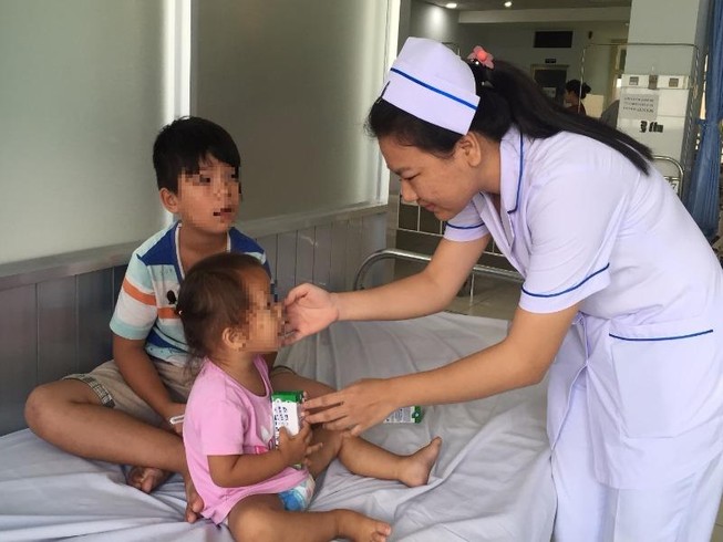Bác sĩ vừa đỡ đẻ vừa chăm sóc 2 con giùm sản phụ