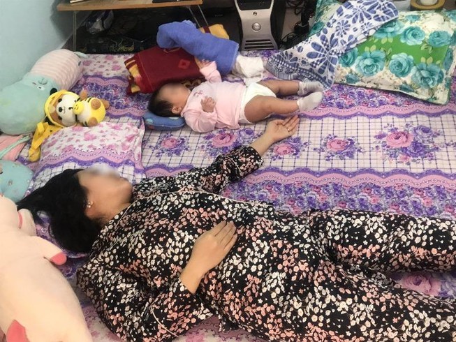 Sau khi sinh bị liệt nửa người, chị T. gặp nhiều bất tiện trong cuộc sống và chăm sóc con. Ảnh: HL