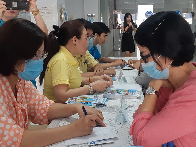 Người dân được cán bộ, nhân viên Bảo hiểm xã hội TP.HCM tư vấn những quyền lợi và cách tham gia bảo hiểm xã hội tự nguyện. Ảnh: NGUYỄN HIỀN