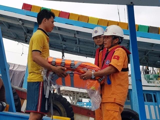 Tổ công tác của tàu SAR tặng áo phao cho ngư dân