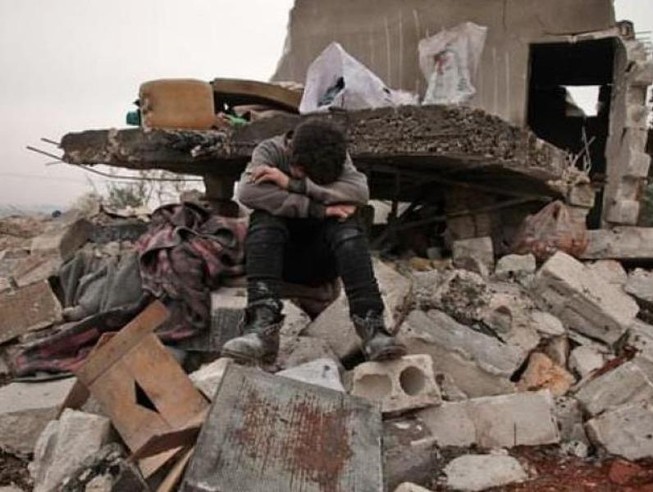 Một cậu bé Syria ngồi khóc ở làng Kafr Taal, tỉnh Aleppo, Syria.