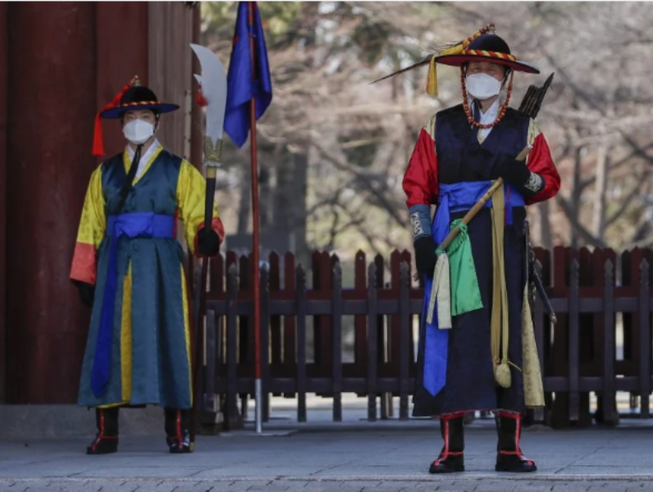 Nhân viên trong trang phục truyền thống đeo khẩu trang tại một cung điện ở Seoul, Hàn Quốc.