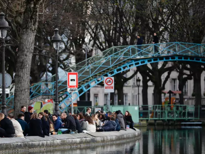 Người dân tập trung tại các bờ kênh đào Saint-Martin ở Paris (Pháp) hôm 25-3 khi các nhà hàng, tiệm cà phê đóng cửa do dịch COVID-19. Ảnh: AFP