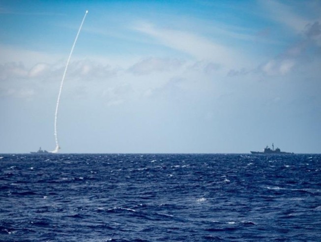 Tàu khu trục USS Barry (trái) phóng tên lửa trong cuộc tập trận bắn đạn thật hôm 19-3.