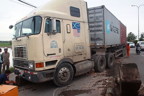 Container húc văng dải phân cách, hai người đi xe máy nhập viện