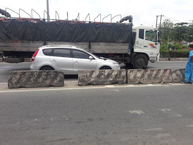 Xe tải ép ô tô vào dải phân cách ở Bình Tân
