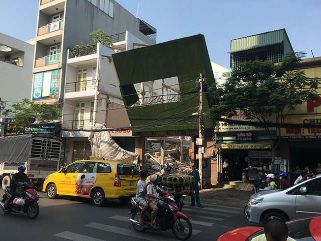 Biển quảng cáo đổ đè trụ điện ở công trình đang tháo dỡ