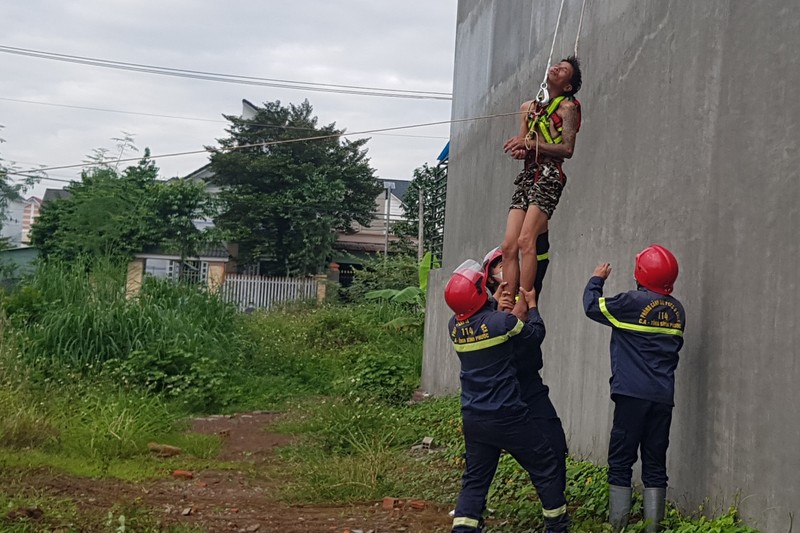 Nghi ngáo đá cầm thanh sắt leo lên nóc nhà la hét - ảnh 1