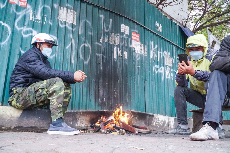 Rét buốt, người lao động Hà Nội nhóm lửa sưởi ấm bên đường - ảnh 1